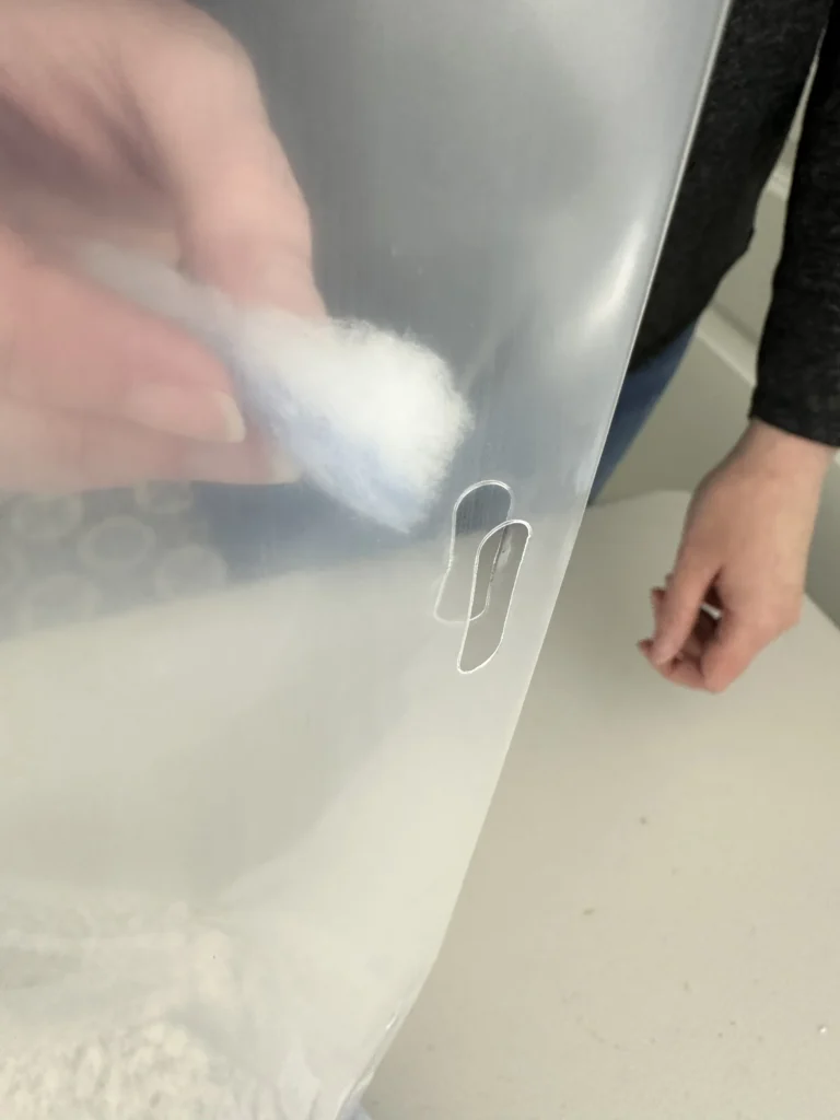 Show: Threading a white filter strip through the laser-cut slits in the side of a Cylo Grow Tent